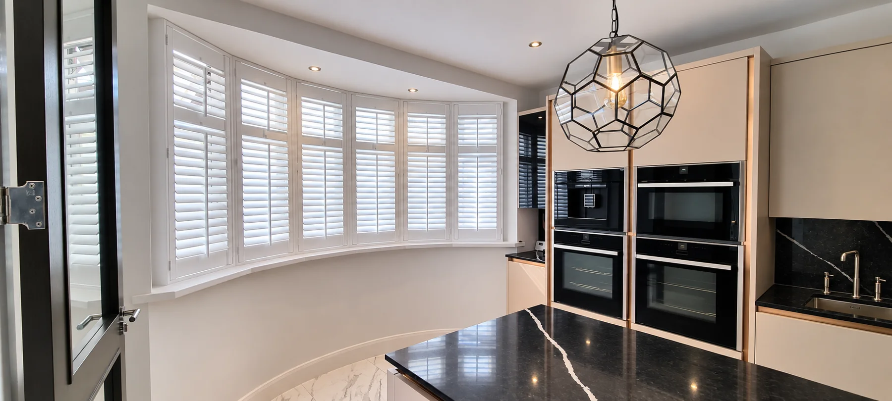 White shutters following a curved living-room bay window