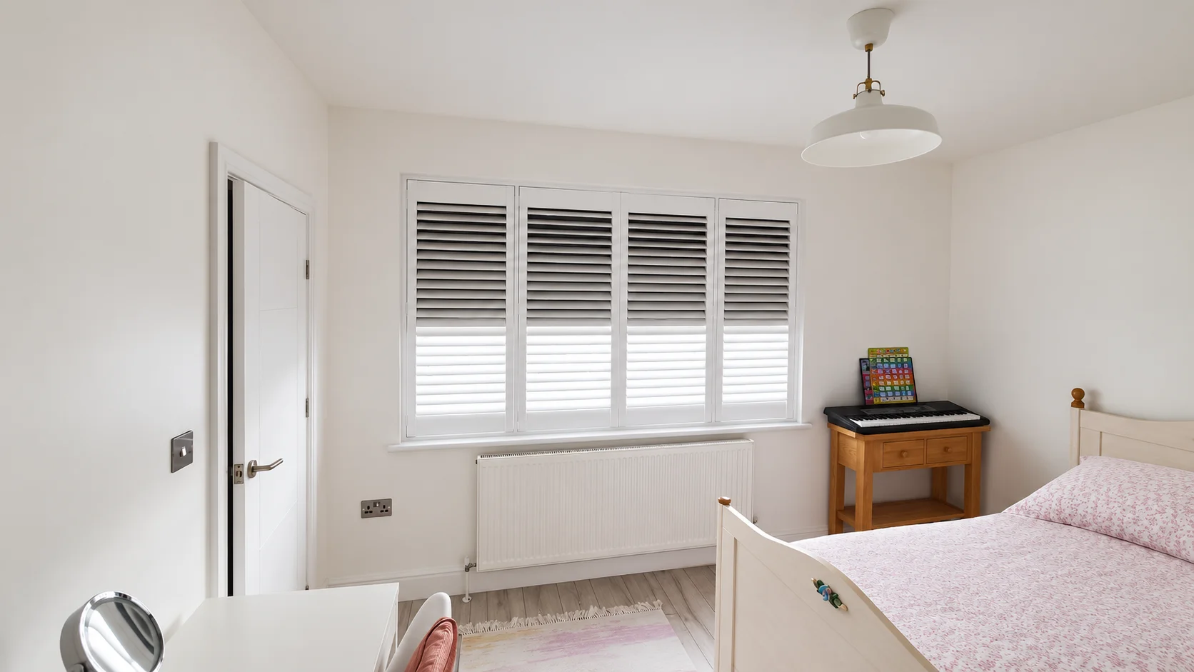 Bedroom shutters with a dark blackout blind behind the louvres