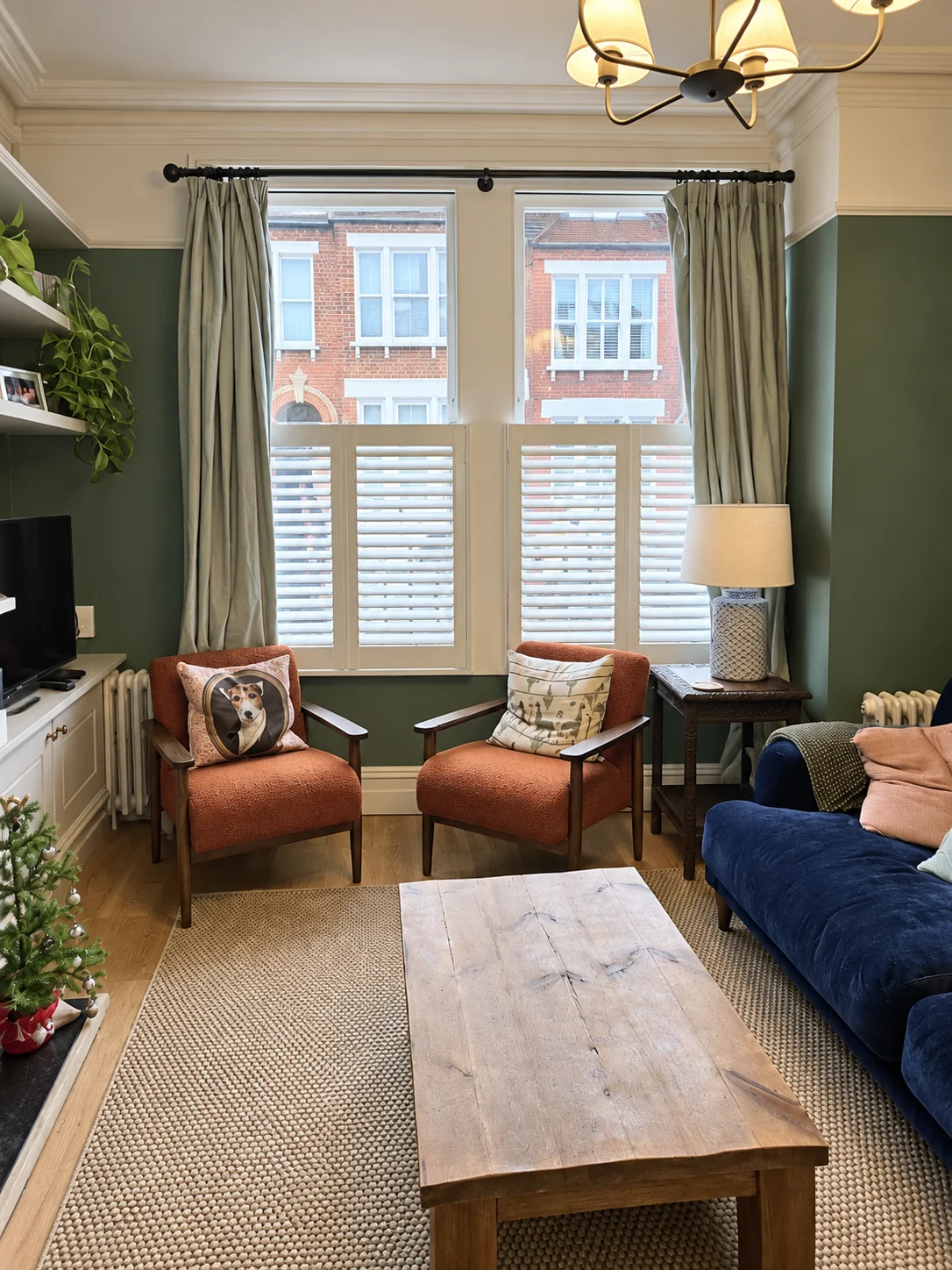 White café-style bay shutters in a room with armchairs