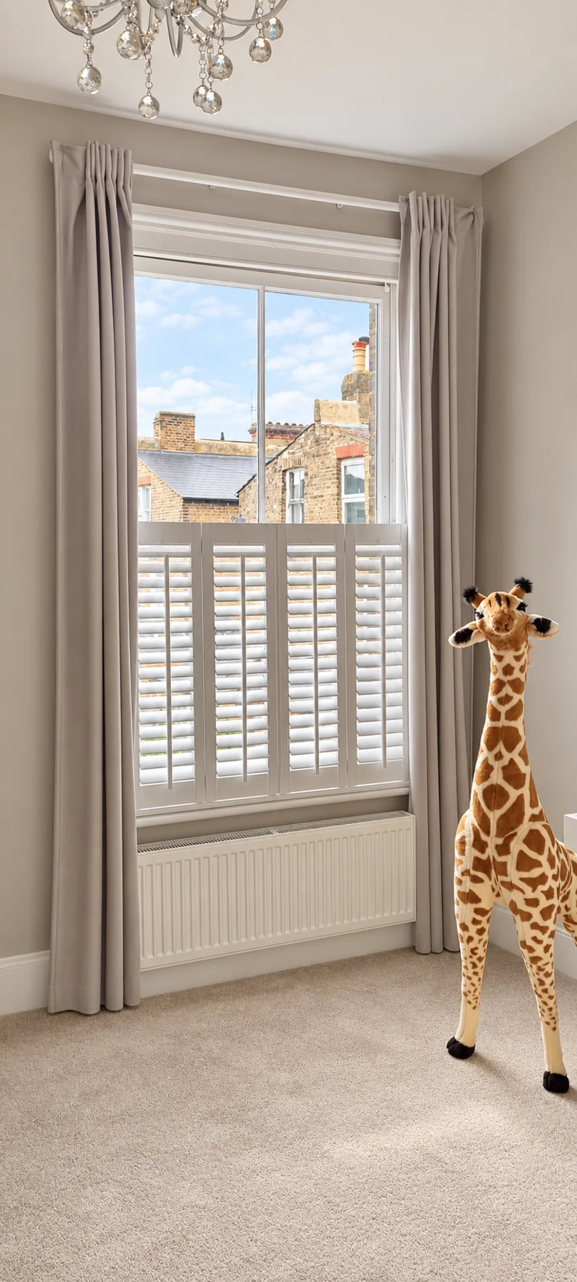 White café-style shutters at a narrow sash window