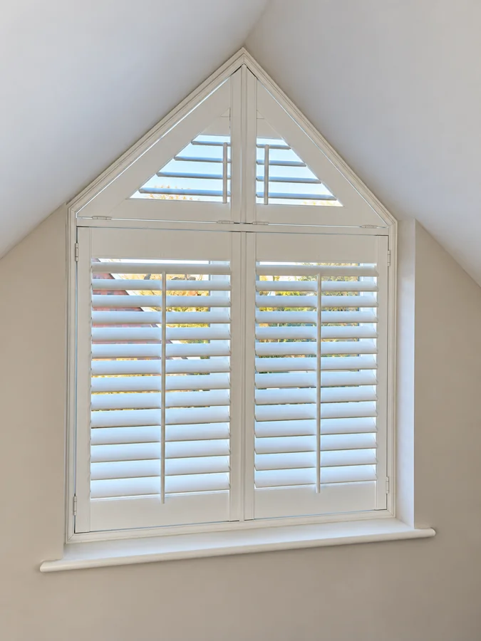 White shutters following a pointed window frame