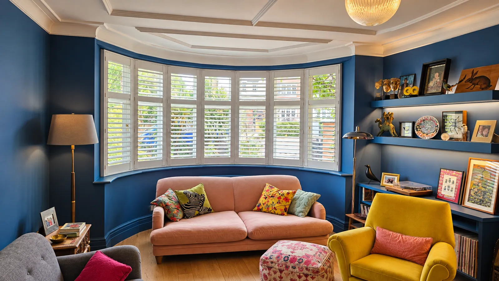 White bay-window shutters in a blue room with yellow seating