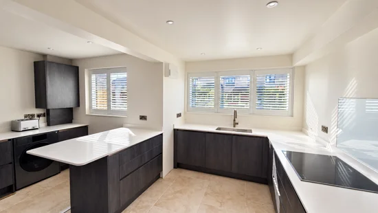 White shutters across windows in a bright kitchen