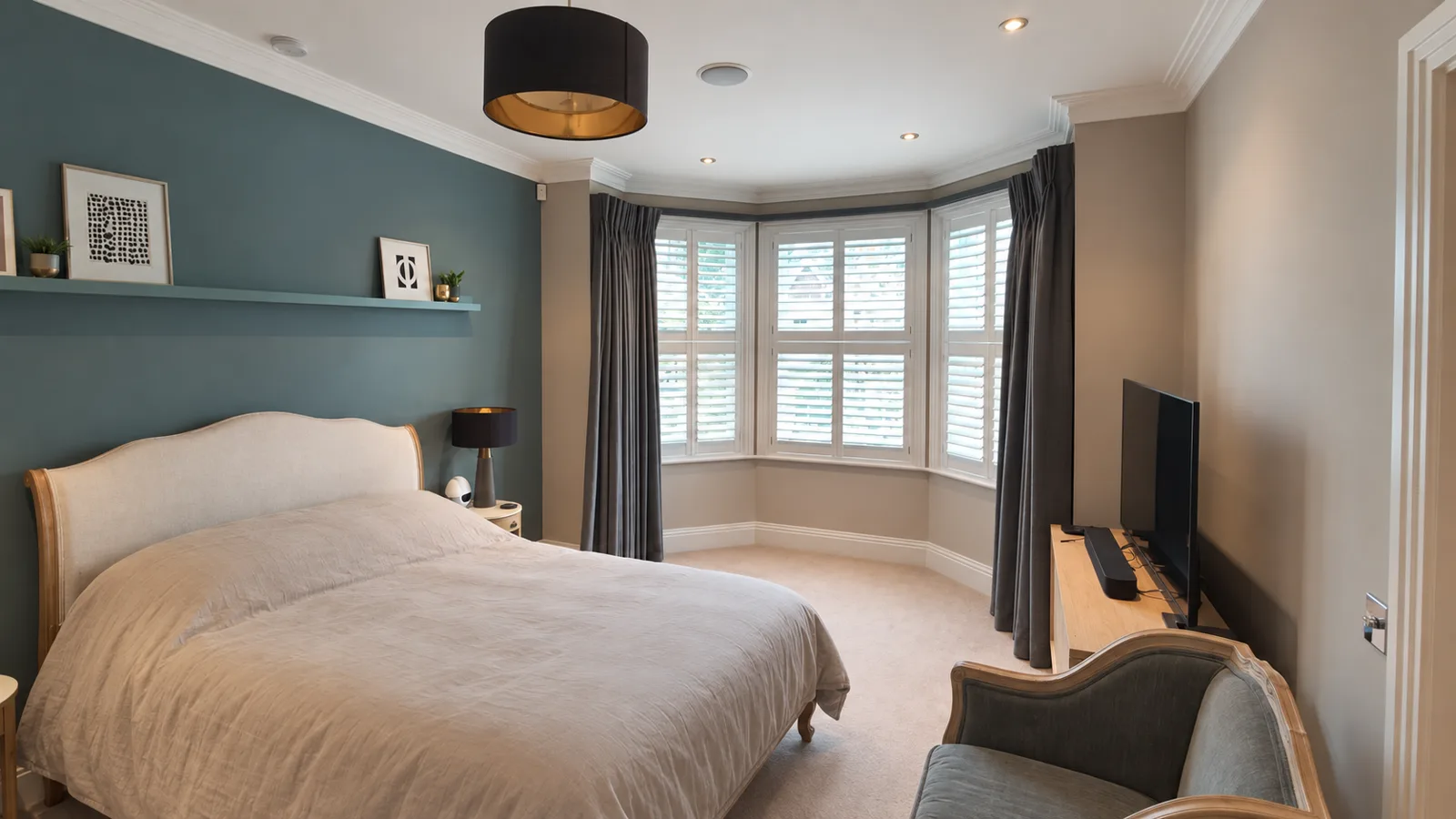 White bay-window shutters in a blue bedroom