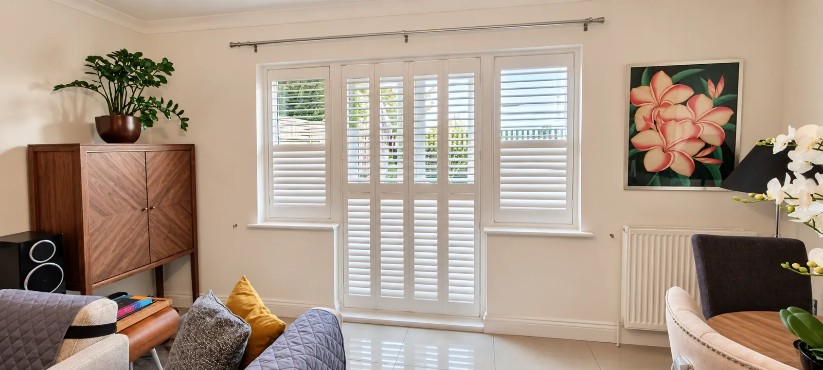 White shutters at French doors beside a chair
