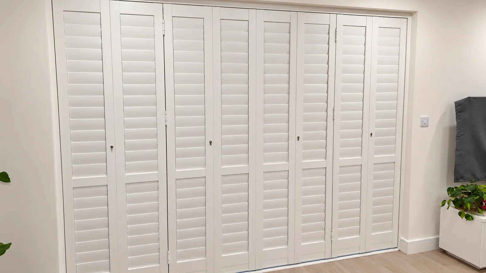 White solid-panel shutters across a wide opening