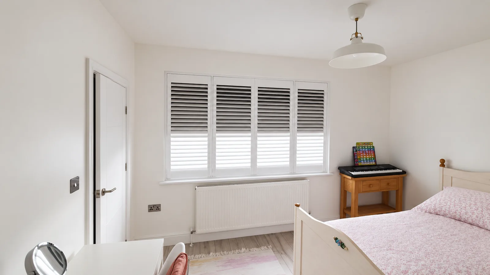 Bedroom shutters with a dark blackout blind behind the louvres