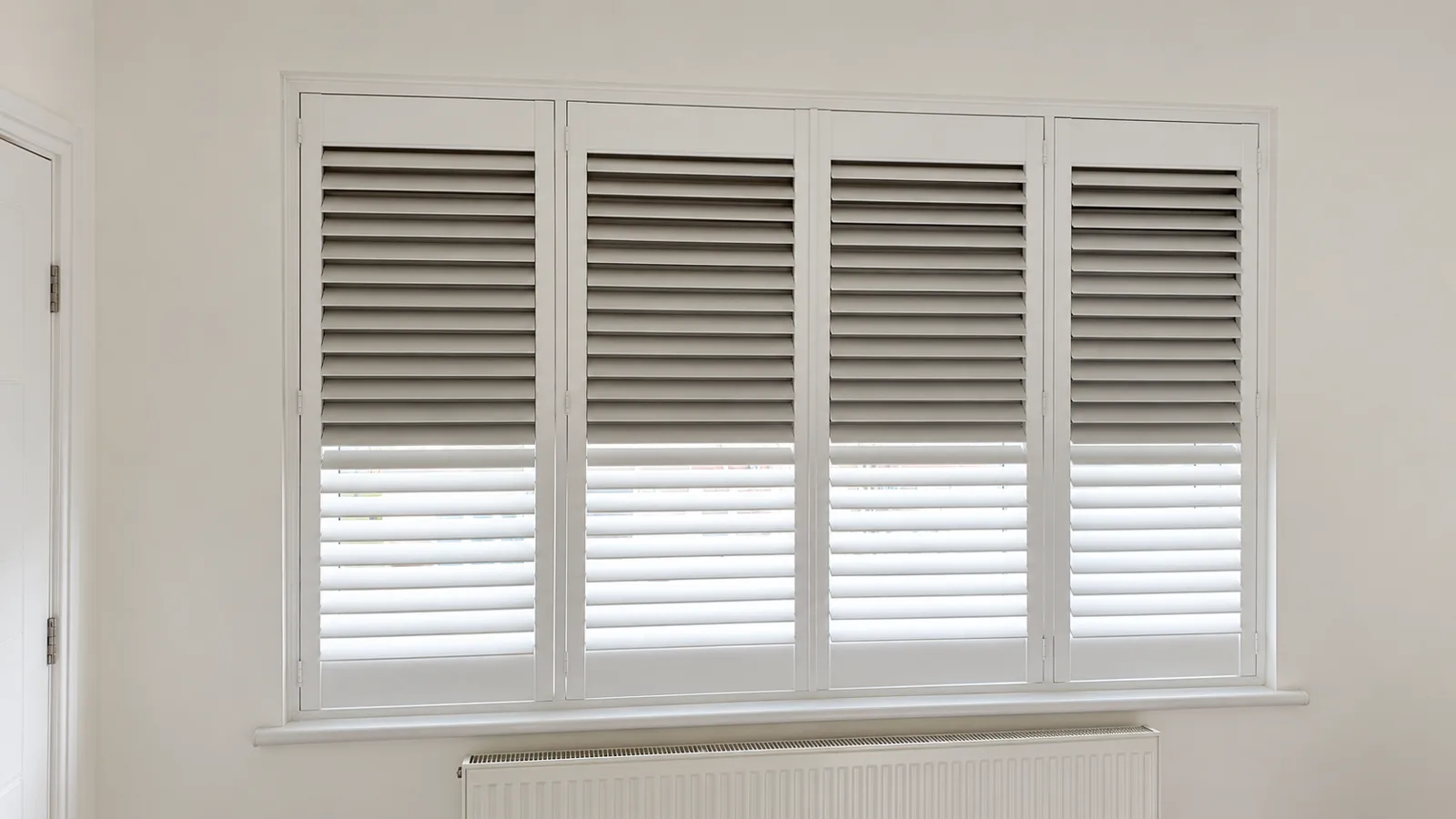 White shutters with dark blackout blinds visible behind them
