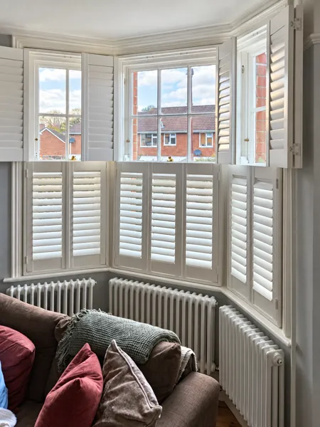 Tier-on-tier Hardwood bay shutters in Basingstoke with the upper panels folded open