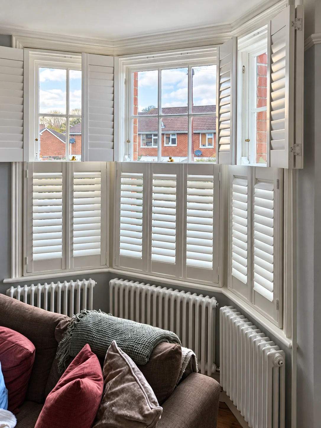 Tier-on-tier Hardwood bay shutters in Basingstoke with the upper panels folded open