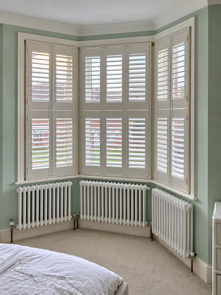 Pure White tier-on-tier Hardwood shutters at a mint-coloured bedroom bay in Basingstoke