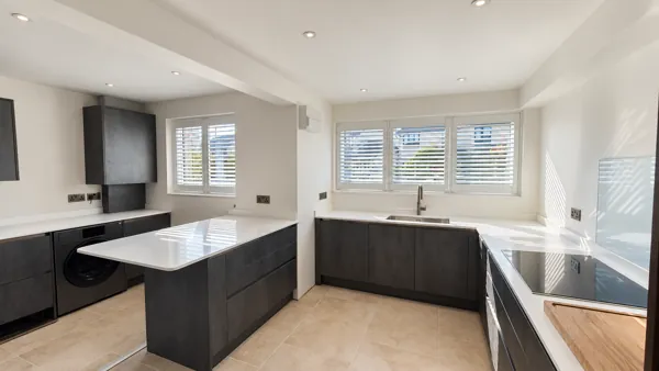 Pure White Composite shutters across two renovated kitchen windows in Gloucester