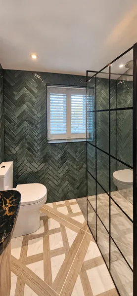 Full-height Pure White Composite shutters beside green herringbone tiles in a Hermitage wetroom