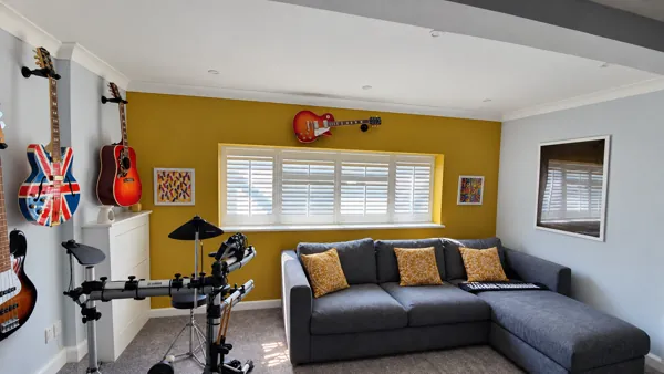 Pure White Hardwood shutters in a mustard-coloured music lounge in High Wycombe