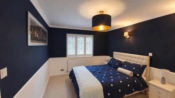 Pure White Hardwood plantation shutters in a navy bedroom in High Wycombe