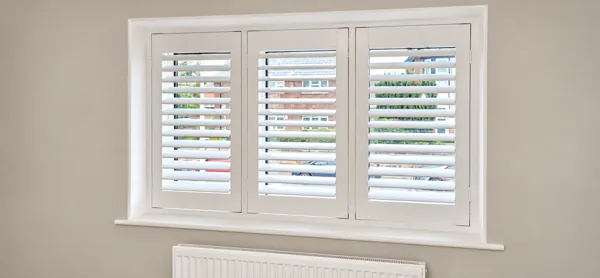 Three-panel Composite shutters at a dining-room window in Newbury